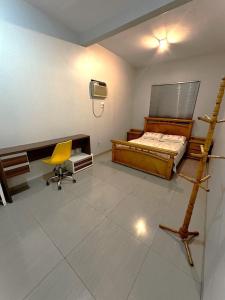 a bedroom with a bed and a desk and a chair at Hospedagem aconchegante com área gourmet in Araguaína