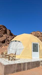 una tenda con sedie e una porta nel deserto di Rum Mars camp a Wadi Rum