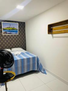 una camera con letto e sedia di Pousada hostel praia itapua a Salvador