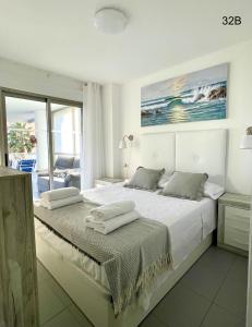 a white bedroom with a large bed with a view of the ocean at TIMORA SEA VIEW New Apart' Hipocampos in Calpe