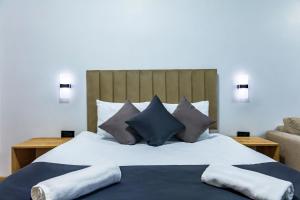 a bedroom with a large bed with blue and grey pillows at Mia Mia Suites in Istanbul