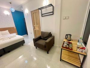 馬米基里的住宿－考馬拉旅館，一间卧室配有一张床、一把椅子和一张桌子