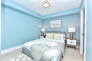a bedroom with blue walls and a bed with white pillows at Bombay Suites in Toronto