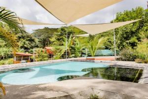 una piscina en un patio con árboles en Bamboo River House and Hotel, en Dominical