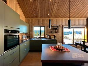 een keuken met een tafel en een fruitschaal bij New cabin with jacuzzi, sauna and ski inout in Svingvoll