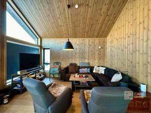 een woonkamer met een bank en een tafel bij New cabin with jacuzzi, sauna and ski inout in Svingvoll