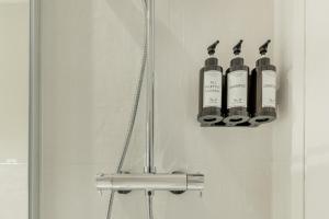 a bathroom with three bottles of wine hanging on a door at Coqueto Apartamento en Delicias in Madrid