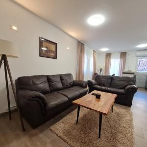 a living room with a leather couch and a table at APARTMAN011 in Mirijevo