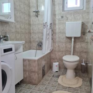 a bathroom with a toilet and a tub and a sink at APARTMAN011 in Mirijevo