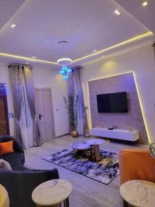 ein Wohnzimmer mit Sofas und einem Flachbild-TV in der Unterkunft Somek Homes2 in Lekki