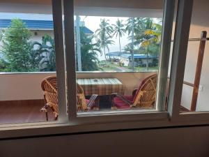 a view of a balcony with chairs and a couch at Seashore Beach Resort Varkala in Varkala