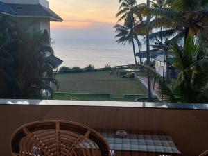 a balcony with a chair and a view of the ocean at Seashore Beach Resort Varkala in Varkala