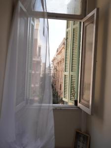 a window with a white curtain and a view of a city at Rhala Hostel Egypt in Cairo