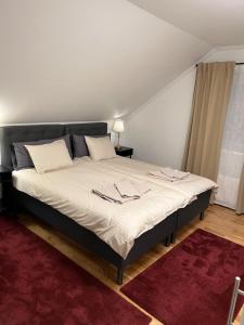 a large bed in a room with a red rug at Noah Longstay Apartment in Västerås