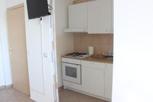 a kitchen with white cabinets and a stove top oven at bariairport in Bari