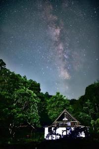 a house under a night sky with the milky way at Chumang River Nest in Thode