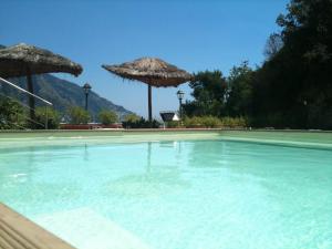 a large swimming pool with two umbrellas on top of it at Hotel Posa Posa in Positano
