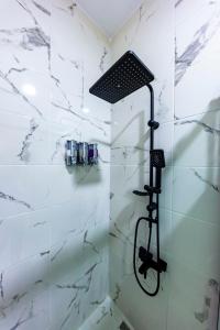 La salle de bains est pourvue d'une douche et de murs en marbre blanc. dans l'établissement Mia Mia Suites, à Istanbul
