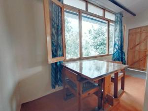 - une table dans une chambre avec fenêtre dans l'établissement Himalaya View, à Rānīkhet