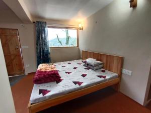 een slaapkamer met een bed met een dekbed erop bij Himalaya View in Rānīkhet +65 foto's