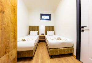 two beds in a room with white walls and wooden floors at Mia Mia Suites in Istanbul