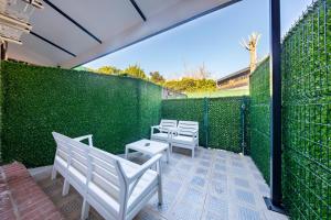 a patio with white chairs and a green wall at Mia Mia Suites in Istanbul
