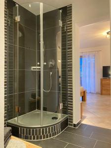 a bathroom with a shower with a glass enclosure at Ferienwohnungen LARA Wohnung 2 in Wallgau