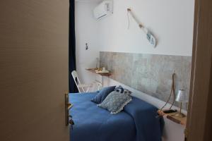 a bedroom with a blue bed with a wall at bariairport in Bari