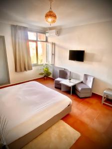 - une chambre avec un lit, un canapé et une télévision dans l'établissement Hotel Bab Mansour, à Meknès