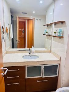 uma casa de banho com um lavatório e um espelho em FIRA Gran Vía 2 - Private Rooms in a Shared Apartment - Habitaciones Privadas en Apartamento Compartido em L'Hospitalet de Llobregat