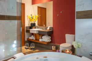 uma casa de banho com uma banheira, um lavatório e um espelho. em Pousada Déllis em Viscode de Mauá