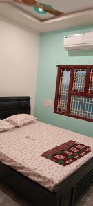 1 dormitorio con 1 cama con edredón en Srinivas service home en Rajahmundry