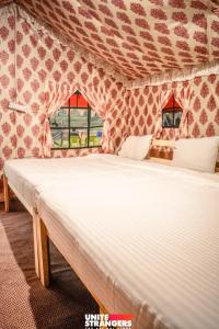 a white bed in a room with a tent at Valley view camps &cottages in Nainital