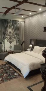 a bedroom with a large white bed and curtains at Madcrew Lodge in Islamabad