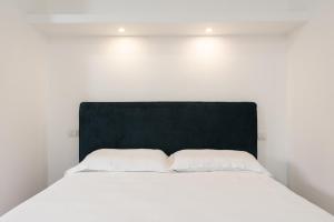 a white bed with a black headboard in a room at Aurelia Deluxe Suites in Rome