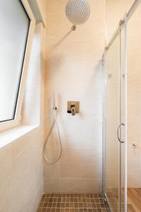 a bathroom with a shower with a glass door at Aurelia Deluxe Suites in Rome