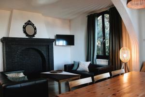 a living room with a fireplace and a table and chairs at Villa les Grillons in Hyères
