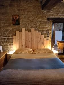 1 dormitorio con 1 cama grande y pared de piedra en #FortCozzo - JacuzziSuite & Sauna - Casola Valsenio, en Mercatale