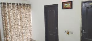 a room with a black door and a curtain at Executive home Stay Sector75 Noida in Noida
