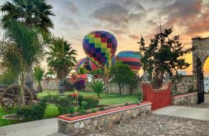 una pintura de tres globos de aire caliente en un campo en HOTEL & SPA HACIENDA TRES VIDAS, en Tequisquiapan