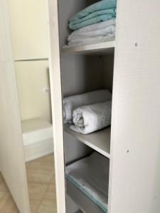 un armadio bianco con alcuni asciugamani sugli scaffali di Sea View Apartment Anabel a Vlorë