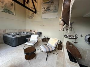 a bathroom with a sink and two chairs and a tub at Unieke Wellness Boerderij - Vlaamse Ardennen in Zottegem