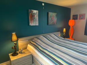 a bedroom with a bed and two paintings on the wall at Unieke Wellness Boerderij - Vlaamse Ardennen in Zottegem