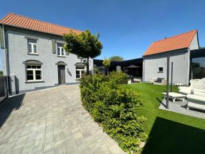 a house with a patio and a yard at Unieke Wellness Boerderij - Vlaamse Ardennen in Zottegem