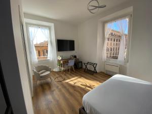 a white bedroom with a bed and a desk and two windows at Belltower Elegans in Rome