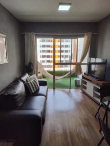uma sala de estar com um sofá e uma televisão em Seu Apê Ponta Verde- 02 QUARTOS - 2 banheiros - Ao lado do restaurante Janga em Maceió
