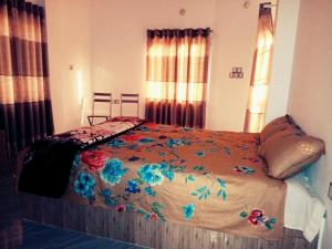 a bedroom with a bed with flowers on it at Juri Cottage: Duplex style, Sylhet divison, Bangladesh 