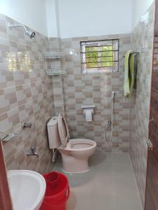 a bathroom with a toilet and a sink at Juri Cottage: Duplex style, Sylhet divison, Bangladesh 