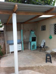 an outdoor kitchen with awning and a stove at Acordar com o cantar do passaro in Jabuticabal