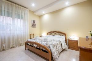 a bedroom with a bed and a dresser and a window at -Etna Sunshine Piedimonte- in Piedimonte Etneo